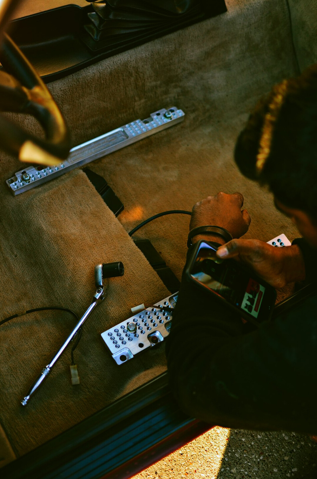 Technician adjusting studio lighting rig above a TV set